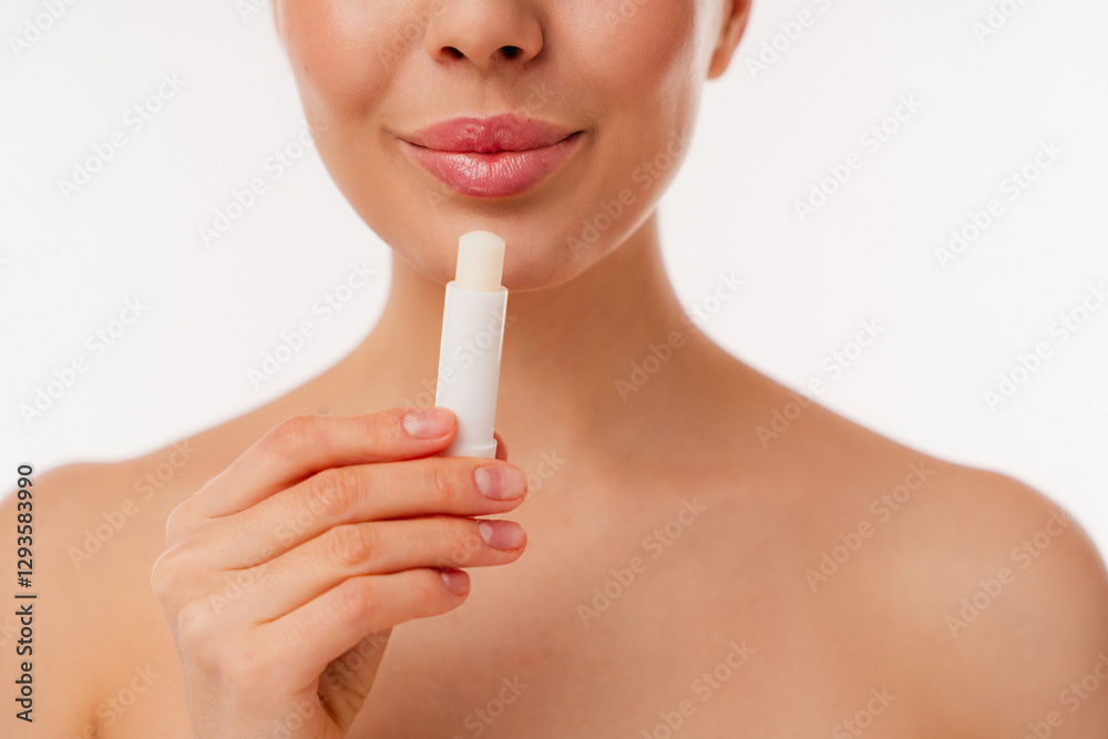 Minimalist portrayal of hand holding lip balm tube with focus on lips showing skin care. Minimalist portrayal of hand holding lip balm tube with focus on lips showing skin care.
