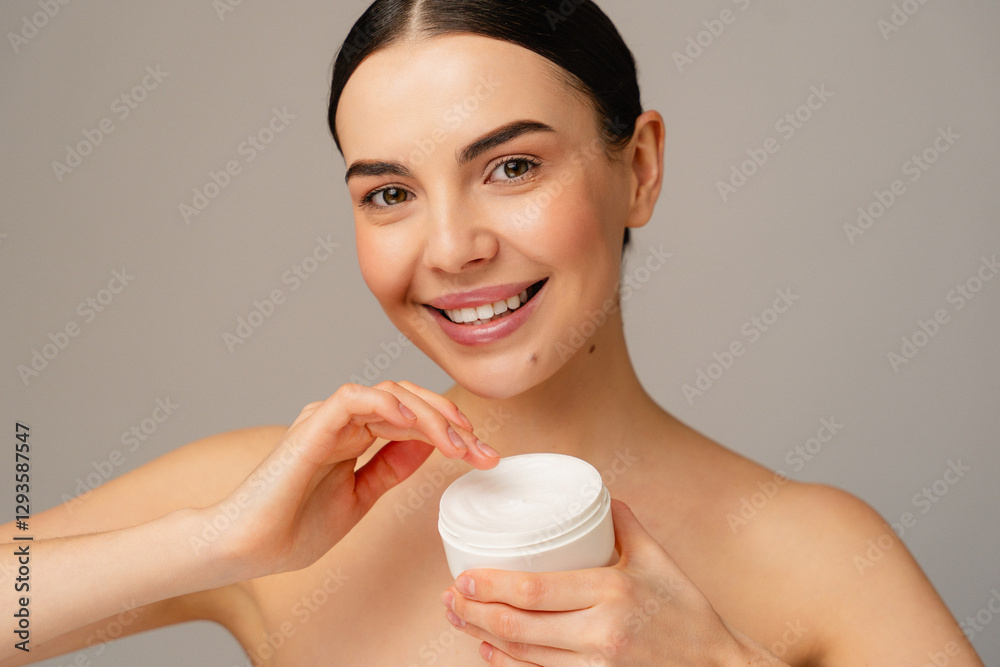 Cheerful individual holding a skincare product, promoting healthy and hydrated skin. Cheerful individual holding a skincare product, promoting healthy and hydrated skin.