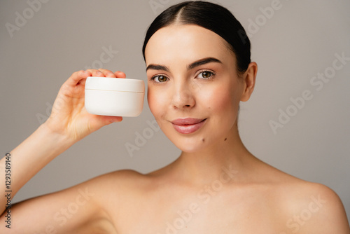 Close-up portrait of woman displaying a cosmetic, suggesting cleanliness, beauty, and care. The neutral background enhances focus on product and subject promoting healthy living and body positivity.
