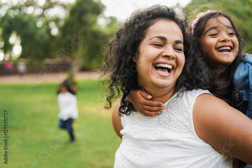 Happy indian mother having fun with her daughter outdoor - Family, mom day and love concept - Main focus on mum face