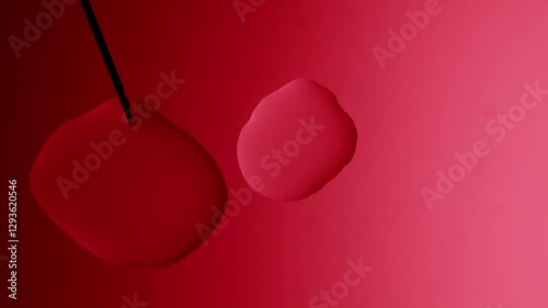 the syringe forms a drop and it connects with another on a red gradient background