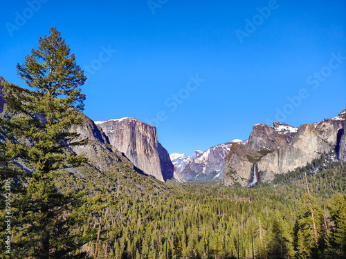 Scenic view of the Yosemite valley from Tunnel View observation point. Snowcapped mountains, trees, waterfall and El Capitan rock formation. California, USA