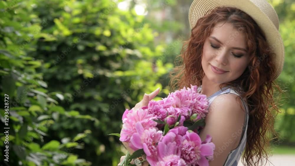 Girl sits on lush green grass and inhales the scent of flowers, listens to birds singing and holds a bouquet of pink peonies, peaceful scene, carefree. Countryside vacation in spring Girl sits on lush green grass and inhales the scent of flowers, listens to birds singing and holds a bouquet of pink peonies, peaceful scene, carefree. Countryside vacation in spring