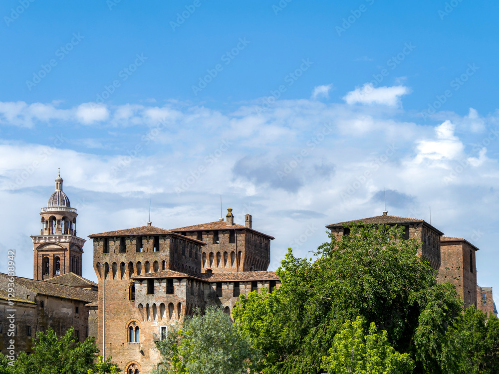 Castello San Giorgio, a castle characterized by its stone walls, arched windows, and battlements. The Campanile of Santa Barbara Palatina is a bell tower with a dome and columns. Mantua, Italy. Castello San Giorgio, a castle characterized by its stone walls, arched windows, and battlements. The Campanile of Santa Barbara Palatina is a bell tower with a dome and columns. Mantua, Italy.