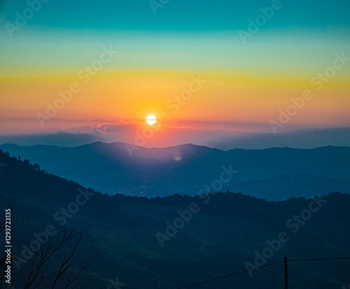 The stunning view from a tourist's standpoint as they go down a hill on a foggy trail with a hill and a background of a golden sky in Forest Park, Thailand. Rainforest. Bird's eye view. Aerial view.