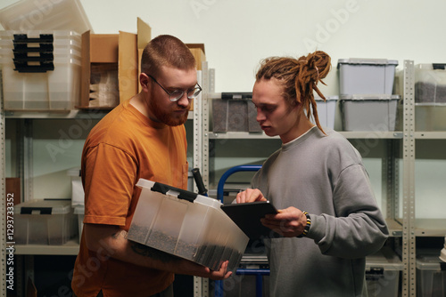 Canvas-taulu Man with dreadlocks comparing coffee brand written on plastic box with online or