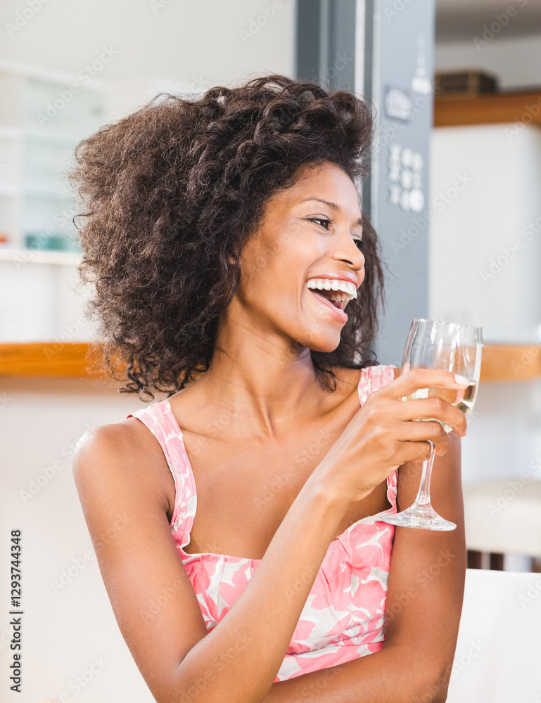 Laughing woman enjoying wine at home, wearing floral dress, feeling joyful Laughing woman enjoying wine at home, wearing floral dress, feeling joyful