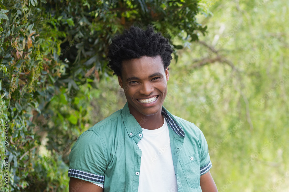 Smiling man enjoying nature, standing outdoors in casual green shirt Smiling man enjoying nature, standing outdoors in casual green shirt