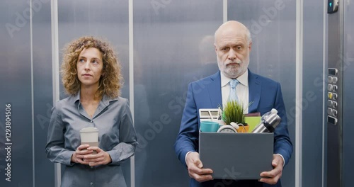 Fired employee carrying his belongings in the elevator