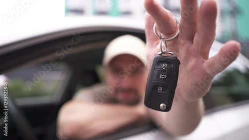 Male hand gives a car keys to male hand in the car dealership close up.