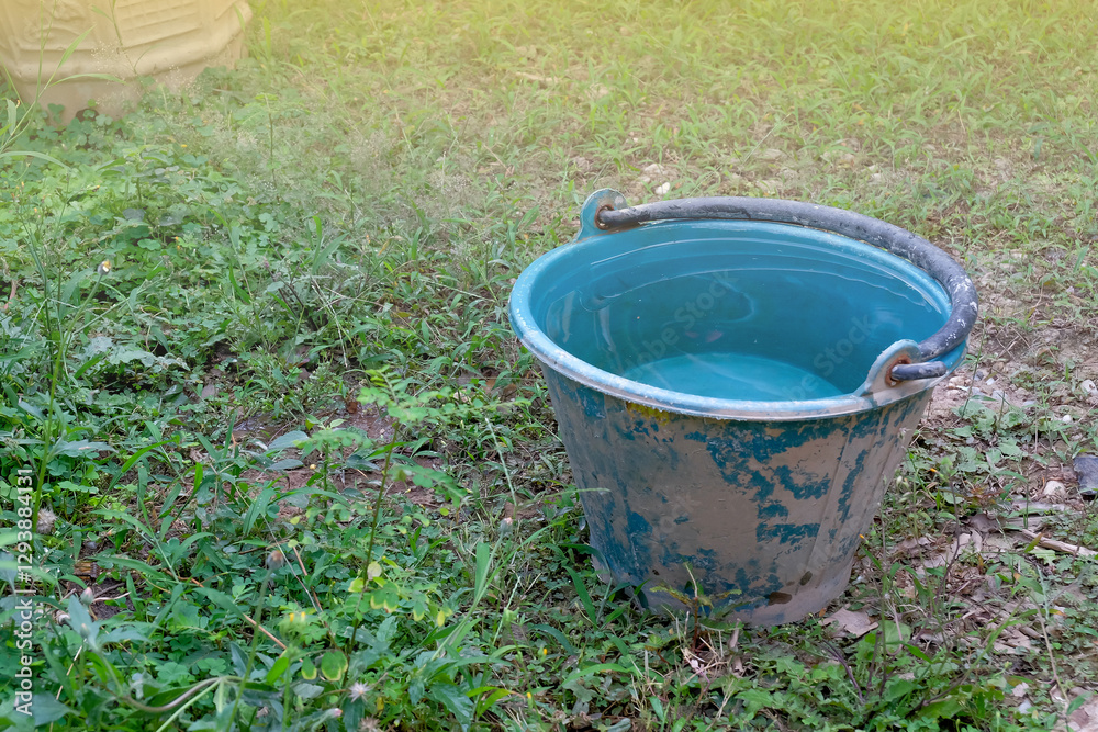 Blue plastic bucket on yard,Bucket used to keep and fill water. Narrow focus image. Blue plastic bucket on yard,Bucket used to keep and fill water. Narrow focus image.