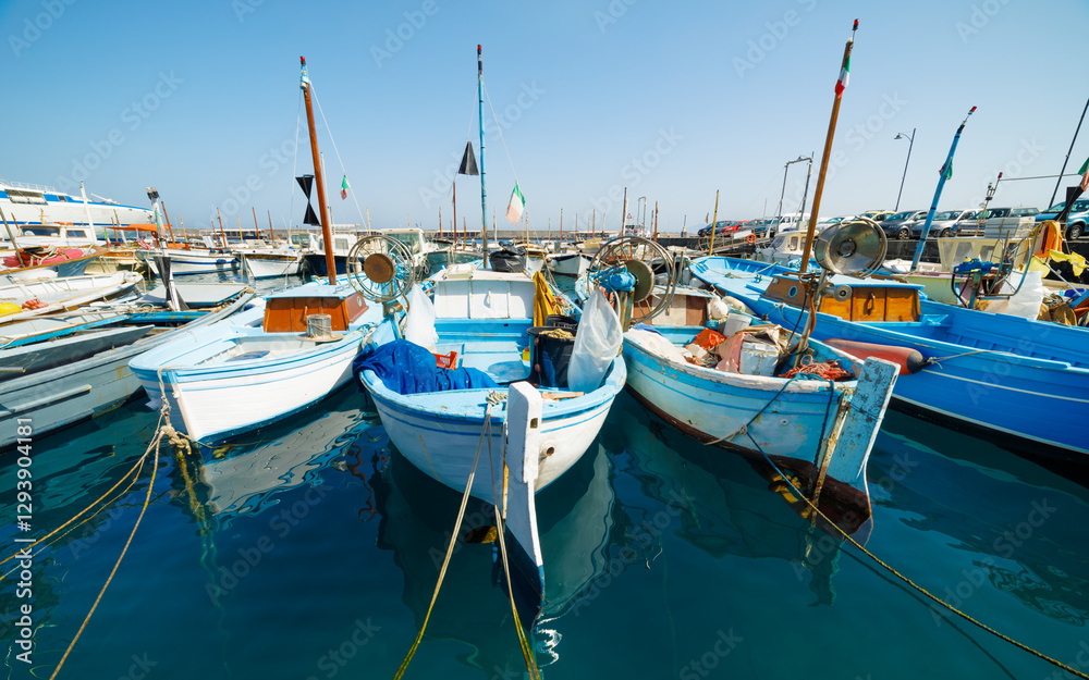 Fototapeta premium Wide angle photo of colorful fishing boats moored in Marina Grande harbor on island of Capri, Italy. Scene highlights charm of Mediterranean life and vibrant colors typical of Capri