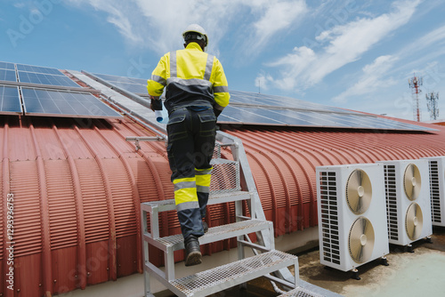 Engineers are checking the hot coil system of the rooftop air conditioner for green energy. Solar panels on the roof for the factory. Solar panels absorb sunlight.