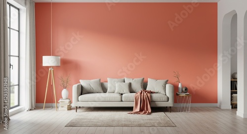 A light beige sofa sits against a coral wall in a minimalist living room. Wooden floor, floor lamp, side table, and neutral decor complete the scene.