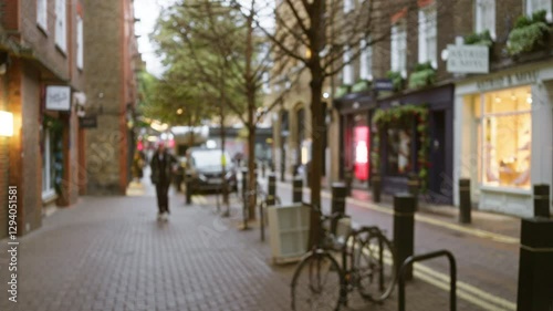 Wallpaper Mural Blurred winter street scene in seven dials, london, with defocused pedestrians and bokeh lights, capturing a traditional uk cobblestone street atmosphere. Torontodigital.ca