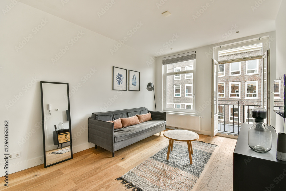 Fototapeta premium A stylish modern living room featuring a grey sofa, a round coffee table, and minimalist decor elements that create a welcoming atmosphere.