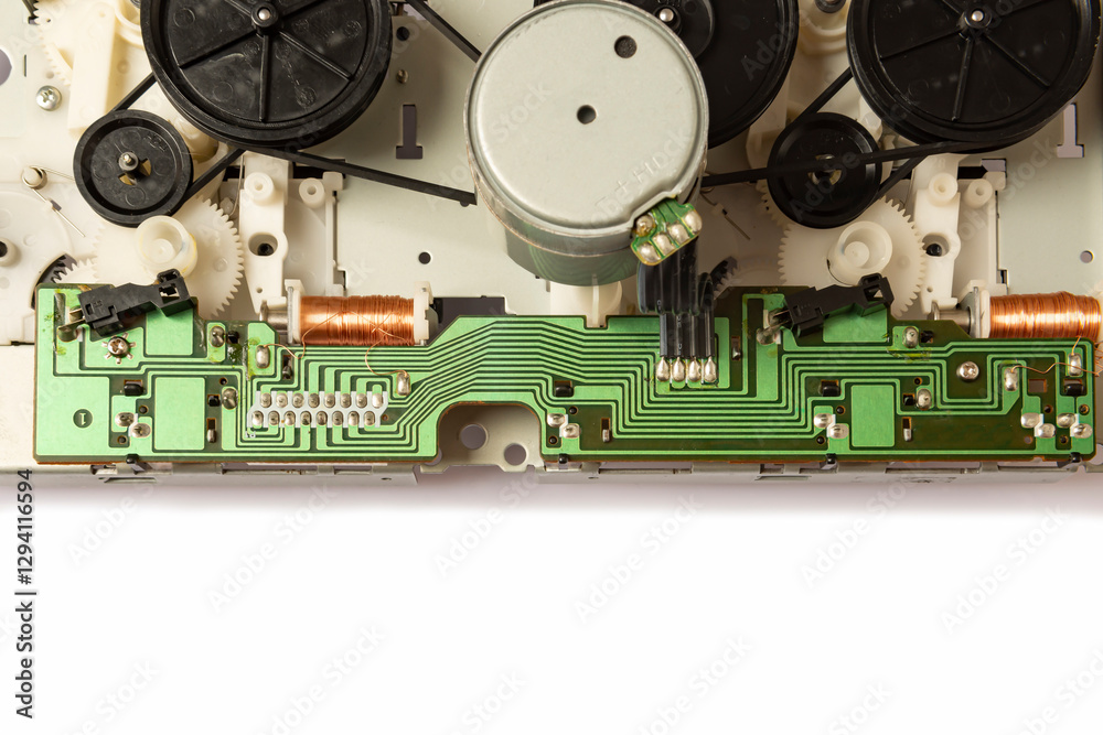 Fototapeta premium Close-up of the magnetic tape drive mechanism of an old double-cassette tape recorder on a white background. Close-up of the magnetic tape drive mechanism. Copy space