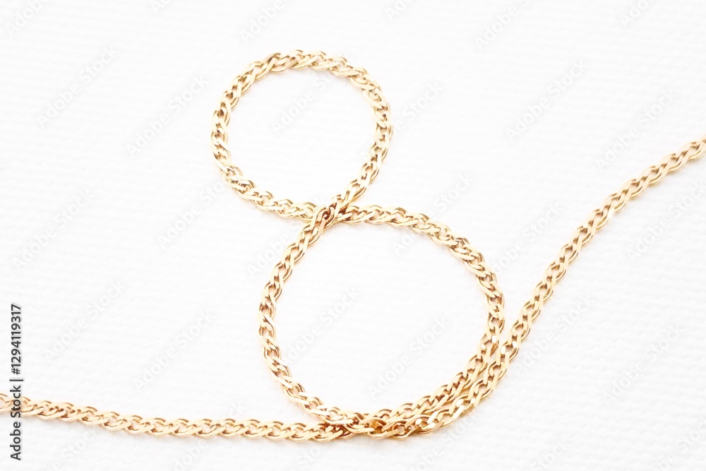 Figure eight made of gold chain isolated on white background.Celebrating International Women's Day. Concept March 8. Figure eight made of gold chain isolated on white background.Celebrating International Women's Day. Concept March 8.