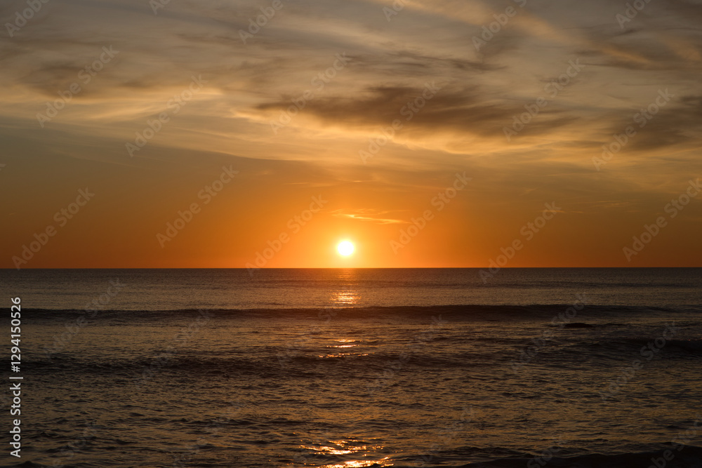The sun reflecting on the sea in the golden hour in the atlantic ocean in Cadiz, Spain. Reflection of golden sunlight on the water. Sunset view of the sea with bright sunlight.