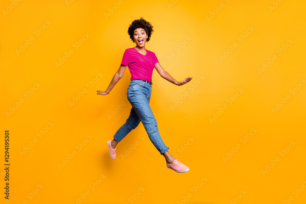 Obraz premium Full body photo of funny funky cheerful lady jump go walk feel crazy have free time wear spring clothes sneakers isolated over yellow color background