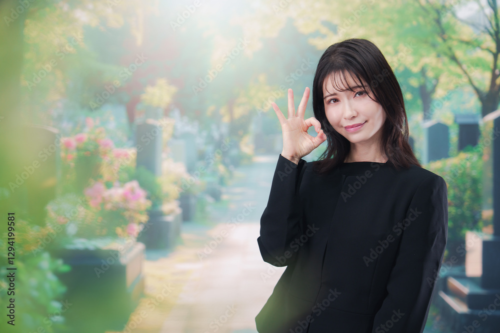 喪服を着てお墓参りをする女性