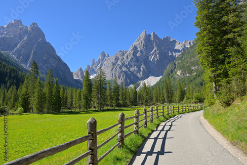 Fototapeta Naklejka Na Ścianę i Meble -  Sunny landscape panorama of valley Val Fiscalina, green meadows, deep blue sky, with view to the summit Einserkofel (Cima Una) at the start of a summer tour. Dolomites (Dolomiti), South Tyrol, Italy