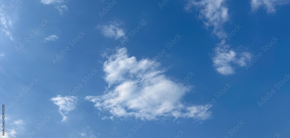 Fluffy clouds scattered across a bright blue sky. Fresh and beautiful charming background for banners, posters and wallpapers. Fluffy clouds scattered across a bright blue sky. Fresh and beautiful charming background for banners, posters and wallpapers.