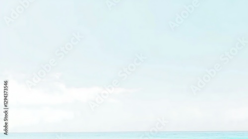 A clear light blue sky with a few fluffy white clouds gently drifting, creating a relaxing and serene outdoor scene.