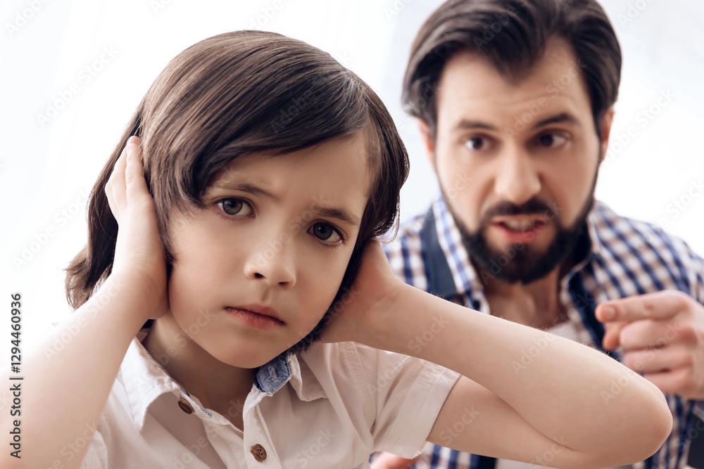 Irate father scolds teenage son which plugs ears. Irate father scolds teenage son which plugs ears.