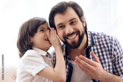 Long haired son tells secret in one's ear of father.