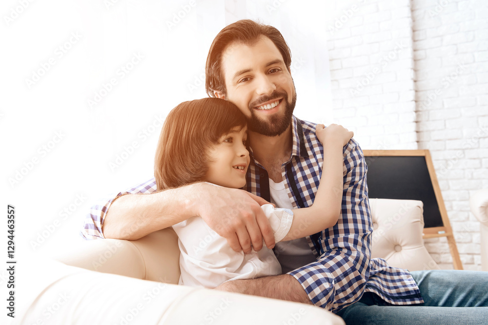 Bearded father embraces with teenager son sitting on the couch. Bearded father embraces with teenager son sitting on the couch.