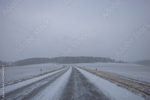 Verschneite Landstrasse mit Schneefahrbahn im  Winter