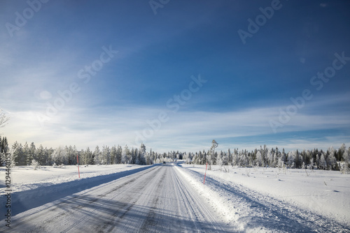 Verschneite Landstrasse mit Schneefahrbahn im  Winter
