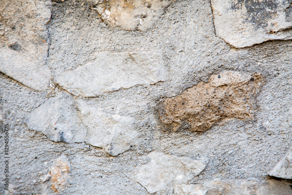 Obraz premium A detailed closeup view of a textured stone wall featuring numerous rocks