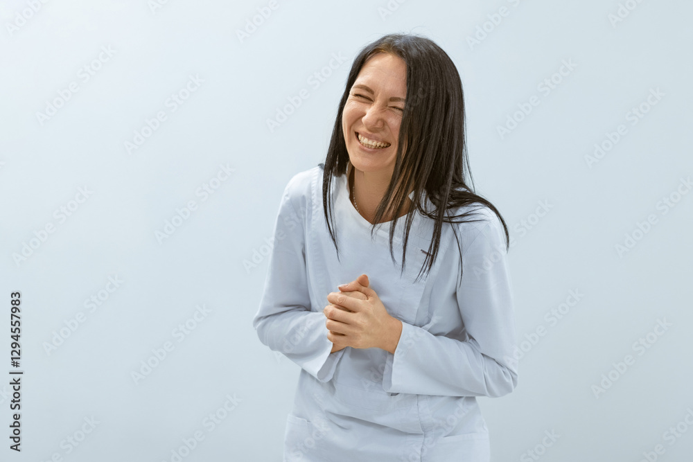 A female massage therapist in a light blue uniform laughing with her hands clasped together, conveying warmth and happiness. A female massage therapist in a light blue uniform laughing with her hands clasped together, conveying warmth and happiness.