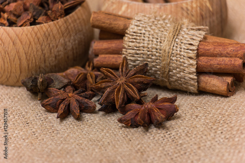 Fototapeta Naklejka Na Ścianę i Meble -  Star anise and cinnamon on burlap background, aromatic spices for cooking and baking