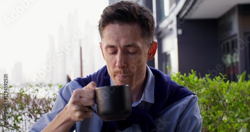 Foto A respectable man is drinking coffee sitting on the terrace of a cafe in the city center