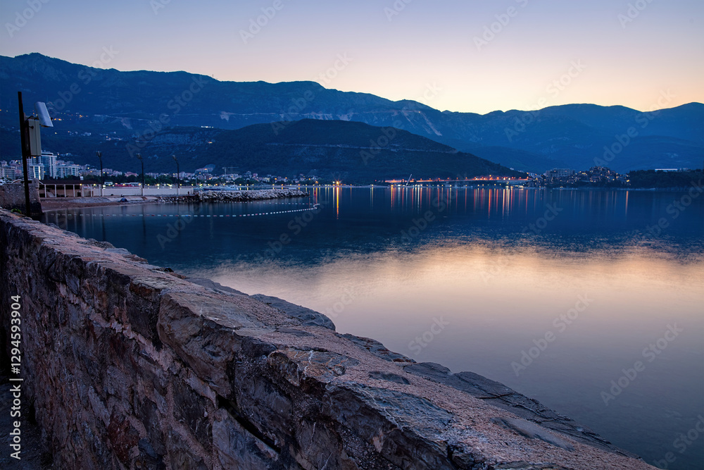 Evening reflections on the tranquil Budva harbor as the light fades.