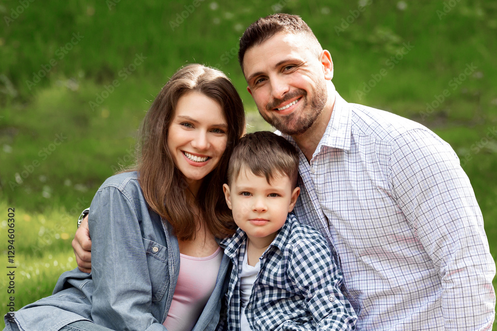 Cute boy with his parents enjoying sunny summer day on picnic in countryside Cute boy with his parents enjoying sunny summer day on picnic in countryside