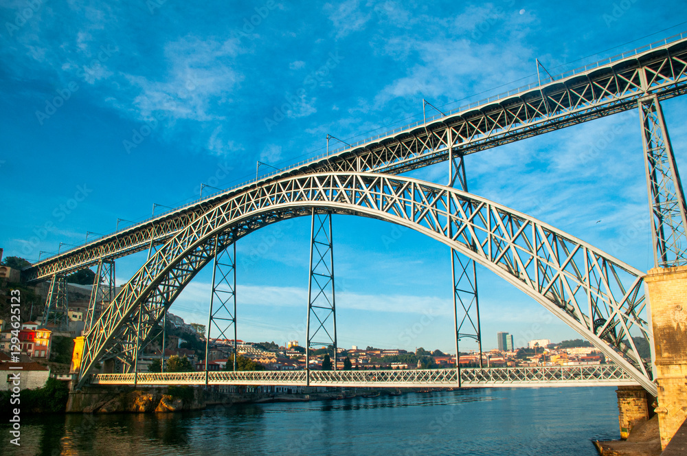 Fototapeta premium Don Luis I Bridge. The majestic arch bridge over the Douro River in Porto, Portugal, on a sunny day. An impressive engineering feat, a historical landmark, and a popular tourist destination.