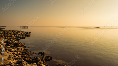 winter sunset over the Scardovari lagoon with fishing boats and cabins inside the delta of the river Po, Porto Tolle, Veneto photo