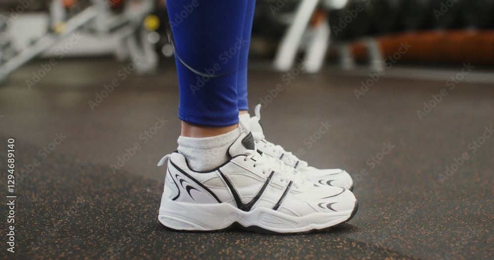 Close-up of female legs jumping rope in modern gym, unidentified identity, woman's face not visible Close-up of female legs jumping rope in modern gym, unidentified identity, woman's face not visible