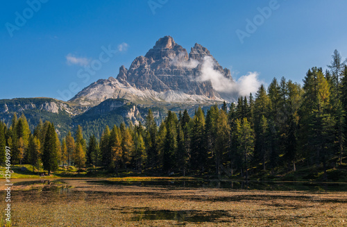 Obraz na płótnie Tre Cime di Lavaredo during sunrise with warm golden light and a lake in the foreground w salonie