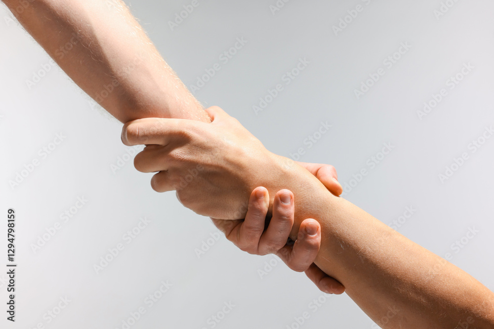 Help and support. People holding hands on light grey background, closeup Help and support. People holding hands on light grey background, closeup