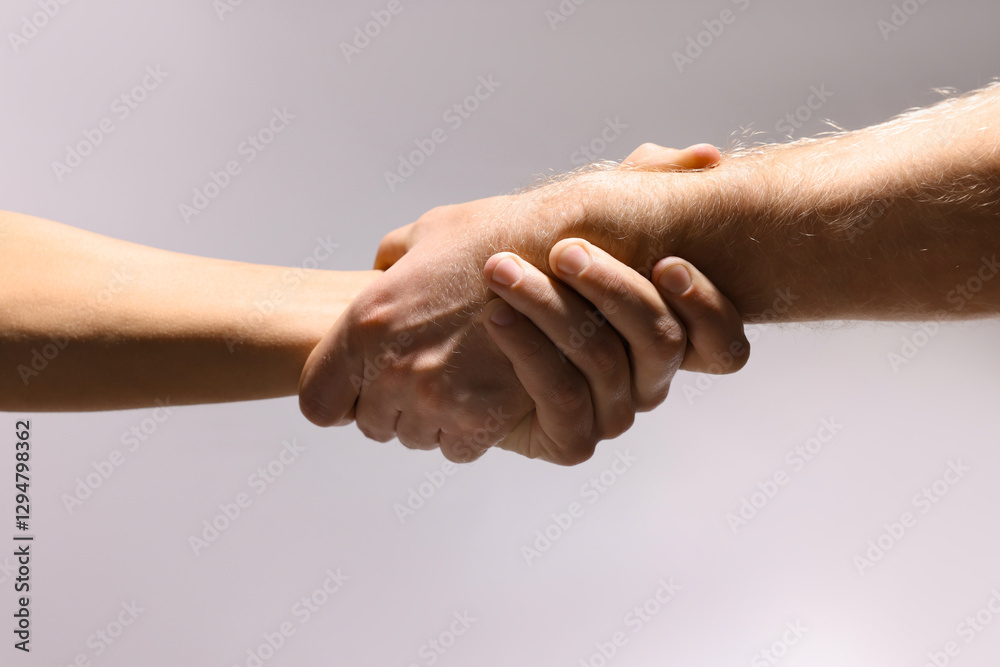 Fototapeta premium Help and support. People holding hands on light grey background, closeup