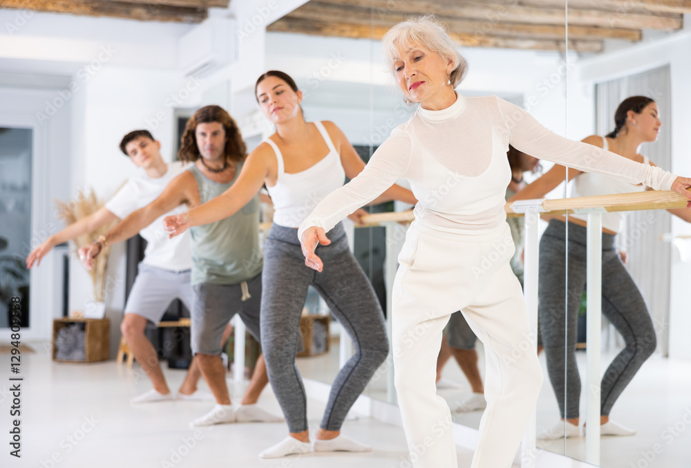Fototapeta premium Concentrated women and men rehearsing ballet dance in studio