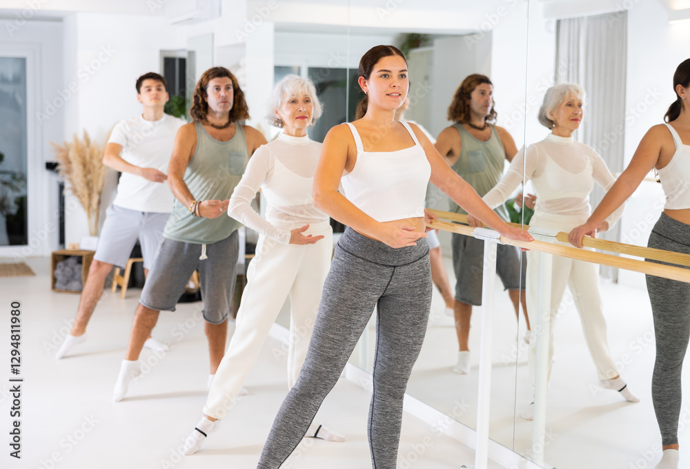 Fototapeta premium Group of people of different ages practice ballet moves in classical dance school.