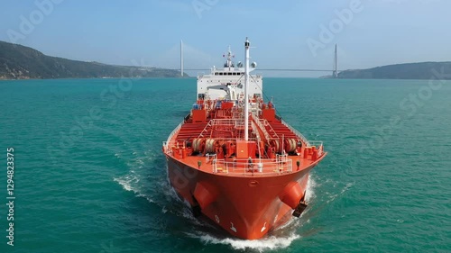 Large red oil tanker ship navigating through Bosphorus, creating a bow wave as it moves forward, with various deck equipment including anchor winches and a mast. Maritime navigation challenges

