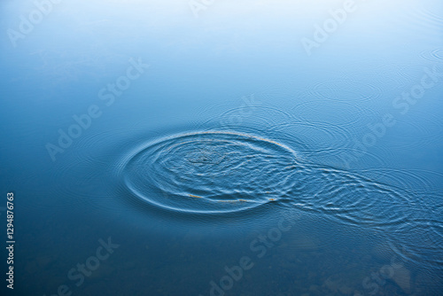 Circular water ripples and bubbles effect. Water ripples and round droplets on blue sea texture pattern background. Liquid motion on calm lake surface. Ring affect, circles