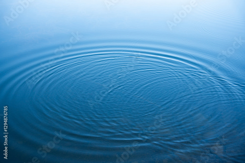 Fototapeta Naklejka Na Ścianę i Meble -  Circular water ripples and bubbles effect. Water ripples and round droplets on blue sea texture pattern background. Liquid motion on calm lake surface. Ring affect, circles